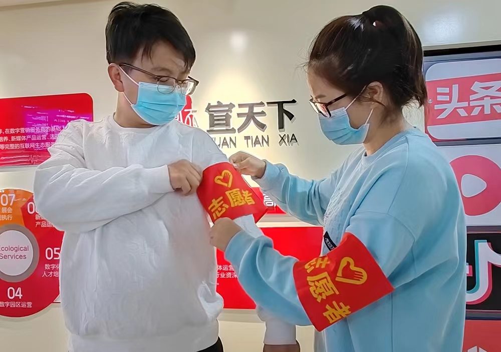 新冠疫情逆行者:员工佩戴志愿者袖标参与疫情防控志愿服务